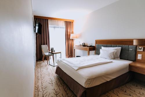 a hotel room with a bed and a desk at Hotel Marina Club in Olsztyn