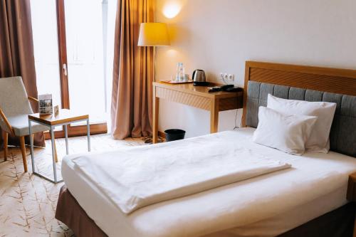 a hotel room with a bed and a desk at Hotel Marina Club in Olsztyn
