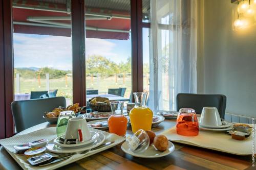 a table with plates of food and orange juice at Hôtel Restaurant Au Relais D'Alsace in Rouffach