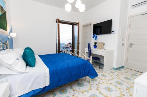 Schlafzimmer mit einem blauen Bett und einem Schreibtisch in der Unterkunft Panariello Palace in Agerola
