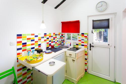 a small kitchen with colorful tiles on the wall at Sweet Home in Valjevo