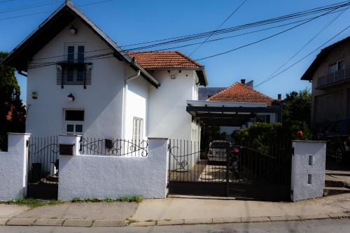 a white house with a gate in front of it at Sweet Home in Valjevo