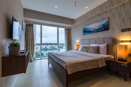 um quarto com uma cama grande e uma janela grande em AR Suites Jewels Royale - Koregaon Park NX em Pune