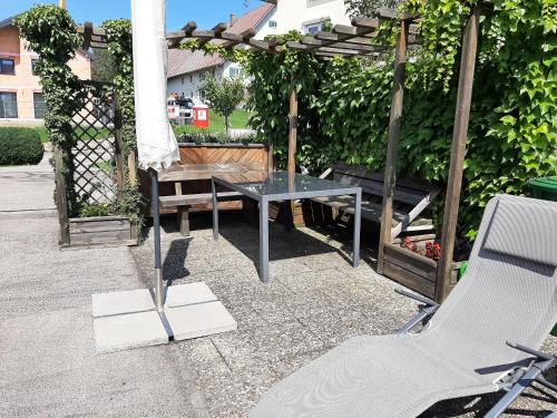 a patio with a table and a bench and a pergola at Allgäu Apartment in Memmingen