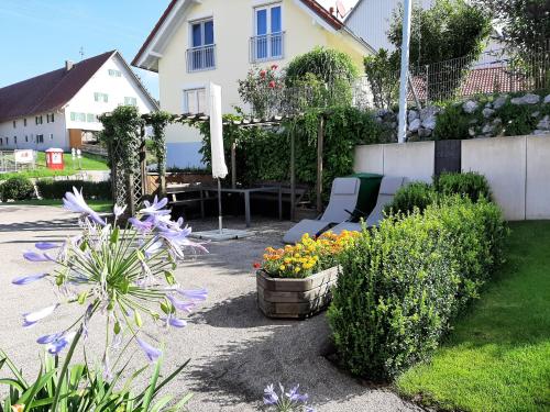 a garden with a chair and flowers in a yard at Allgäu Apartment in Memmingen