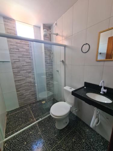 a bathroom with a toilet and a sink at Suites Jangadeiro Maragogi 4 RUA JANGADEIROS 215 in Maragogi