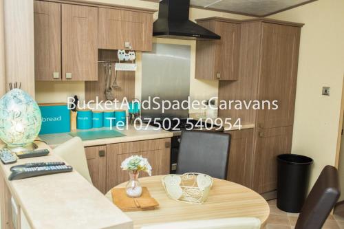 a kitchen with a wooden table and a dining room at Blackpool caravans Marton mere in Blackpool