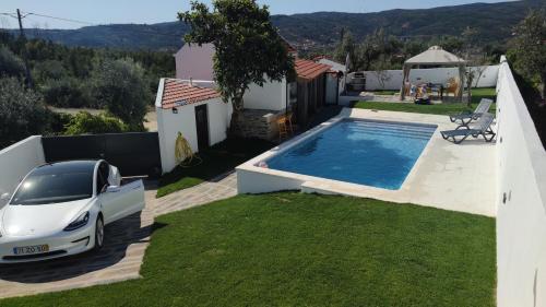 a villa with a car parked next to a swimming pool at Pomar das Oliveiras - Private Swimming pool - Free EV Chrg - Pet Friendly in Carvalhal Cimeiro