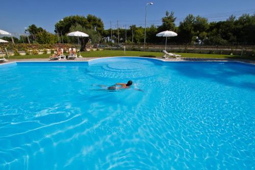 um homem a nadar numa grande piscina azul em Homiday - Mykonos em Pineto
