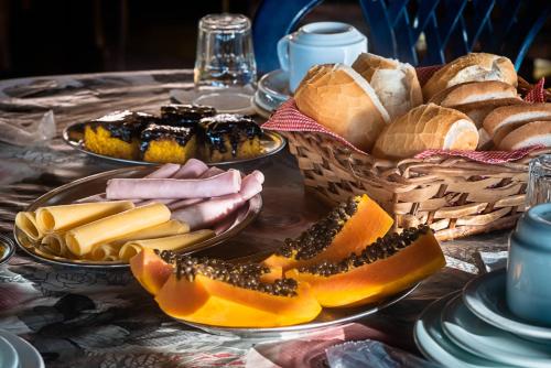 a table with plates of bread and baskets of food at Pousada Acqua Marina in Paraty
