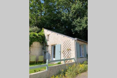 a small stone cottage with a fence and trees at STUDIO indépendant Segré in Segré