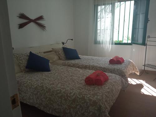 two beds with red slippers on them in a room at Apartamento Maresia in Puerto del Carmen