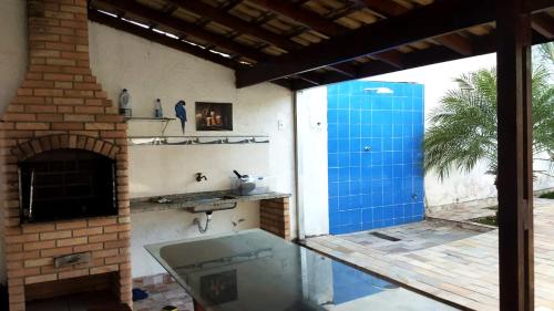 an outdoor kitchen with a tub and a fireplace at Incrivel casa com churrasq e piscina em Peruibe in Peruíbe