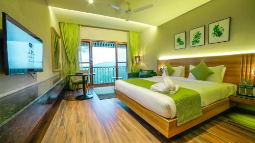 a bedroom with a large bed and a television at Grand Palace Hotel & Spa in Yercaud