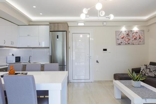a kitchen and a living room with a table in a room at Family Friendly Basilicata Attali villa Private Pool,Children area in Vlikhádha