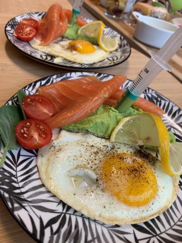 dos platos de comida con huevos y verduras en una mesa en Au petit nid Froissart en Chimay