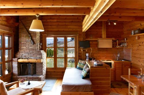 Una sala de estar con chimenea en una cabaña de troncos en Hyades Mountain Resort, en Kato Trikala Korinthias