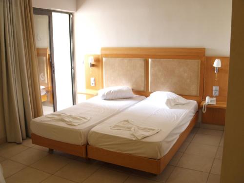 1 dormitorio con 1 cama grande con sábanas blancas en Saint Constantine Hotel, en Cos