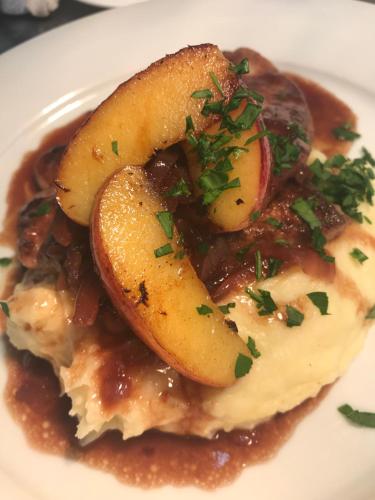 a plate of food with potatoes and gravy at Pensionszimmer im Fliederhof in Michendorf