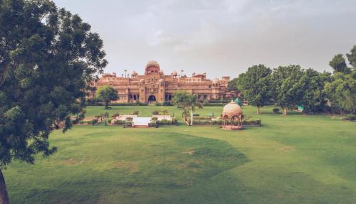 a large building in the middle of a green field at The Laxmi Niwas Palace in Bikaner