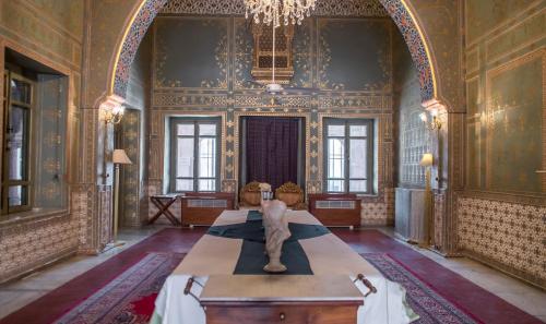 a room with a table with a statue in it at The Laxmi Niwas Palace in Bikaner