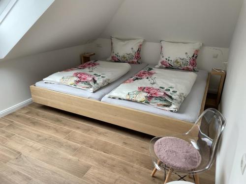 a small bed with two pillows and a chair in a room at Kerschbaumer.Apartments in Waidhofen an der Ybbs