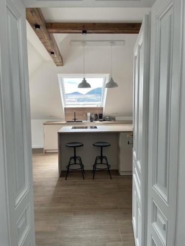a kitchen with a sink and two stools at Kerschbaumer.Apartments in Waidhofen an der Ybbs