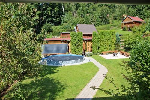 a backyard with a swimming pool and a house at Chata U lesa in Svoboda nad Úpou