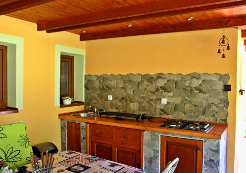 a kitchen with a stone wall and a stove at Chata U lesa in Svoboda nad Úpou