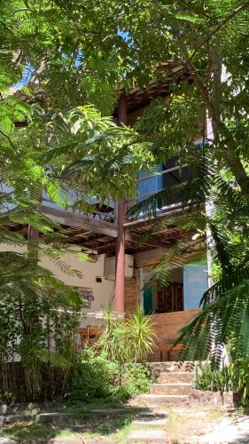 a building with stairs in front of it with trees at Refúgio do Corsário-Imbassai-Ba in Imbassai