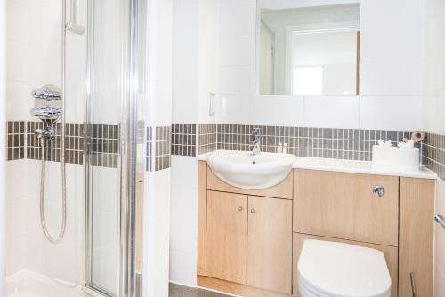 a bathroom with a toilet and a sink and a shower at City Stay Apartments - Vizion in Milton Keynes