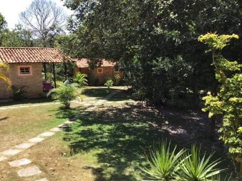 a yard with a house and trees and grass at Refúgio do Corsário-Imbassai-Ba in Imbassai