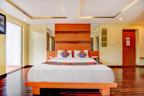 a bedroom with a large bed in a room at FabHotel Abirami Grand Inn in Kodaikānāl