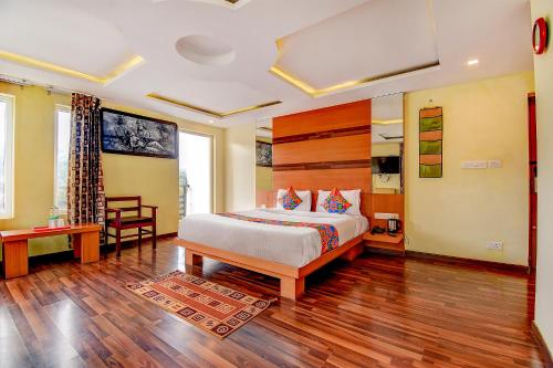 Schlafzimmer mit einem Bett und Holzboden in der Unterkunft FabHotel Abirami Grand Inn in Kodaikanal