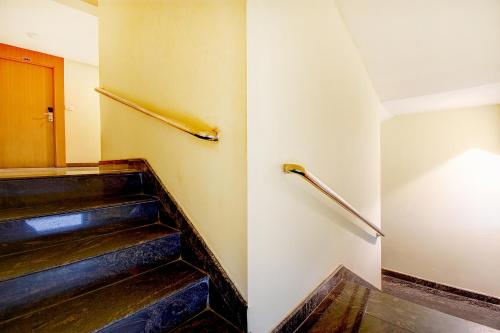 a staircase in a building with a stair railing at FabHotel Abirami Grand Inn - Nr Bryant Park in Kodaikānāl