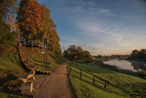 a path next to a river with a fence at Skrundas namiņš in Skrunda