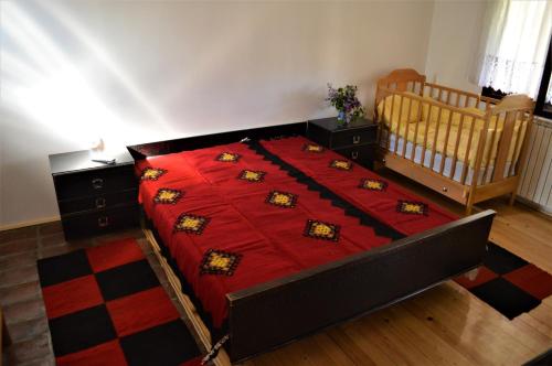 a bedroom with a bed with a red blanket at Šurička bajka in Loznica