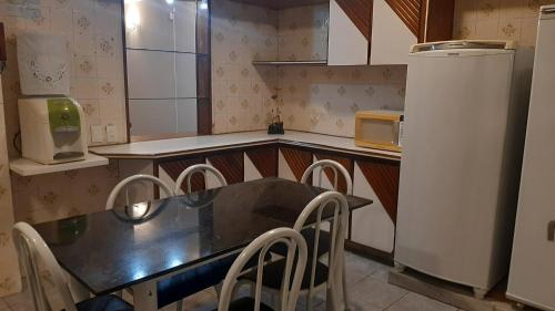 a kitchen with a table and chairs and a refrigerator at Casa para Temporada Natal in Natal