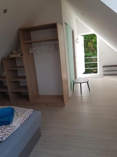 a bedroom with a bed and a table in a room at Hibiskus Appartementhaus in Cserszegtomaj