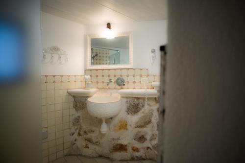 uma casa de banho com um lavatório, um WC e um espelho. em Casetta Letizia em Ostuni
