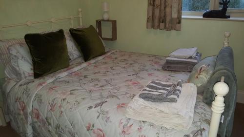 a bed with a blanket and pillows on it at Stag Cottage in Ilkeston