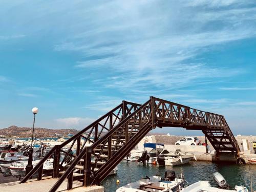 a wooden bridge over water with boats in a marina at Peter's Place Studios & Suites in Faliraki
