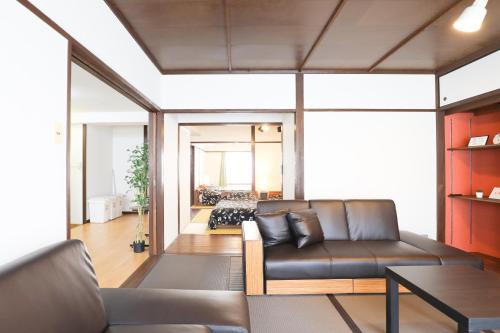 ein Wohnzimmer mit einem Sofa und einem Tisch in der Unterkunft Fukuoka Condominium in Fukuoka