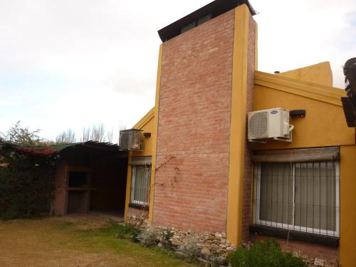 un edificio de ladrillo con aire acondicionado en el lateral en Cabañas Olivos y Bodegas en San Rafael