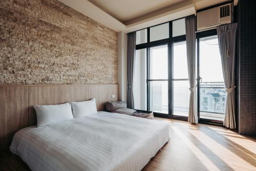 a bedroom with a large bed and a large window at Meet Secret B&B in Donggang