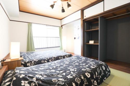 a bedroom with two beds and a window at Fukuoka Condominium in Fukuoka