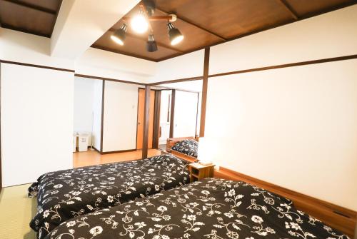 a bedroom with a bed and some windows at Fukuoka Condominium in Fukuoka