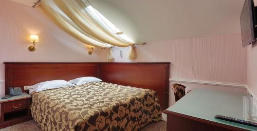 1 dormitorio con cama, escritorio y ventana en Hotel Old City by Home Hotel, en Moscú