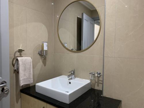 ein Badezimmer mit einem weißen Waschbecken und einem Spiegel in der Unterkunft The Sails G609 in Durban