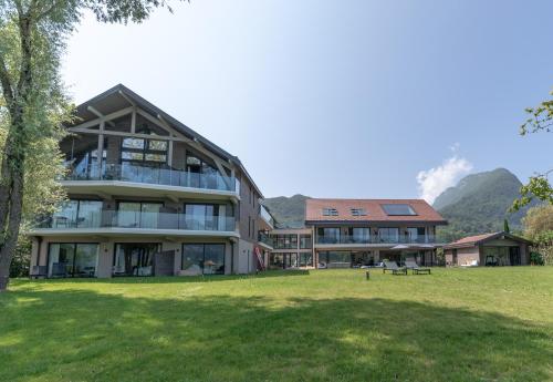 a large building with a grass field in front of it at Villa Caroline, Lac d'Annecy in Duingt